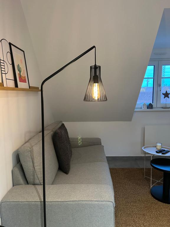 a living room with a couch and a lamp at Charmant appartement avec vue sur les vignes in Ammerschwihr