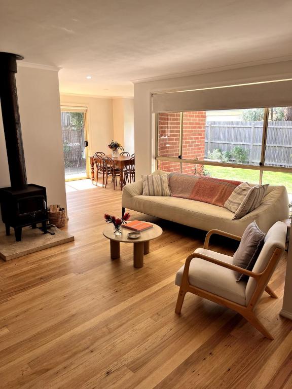 a living room with a couch and a table at Beach Escape Torquay in Torquay