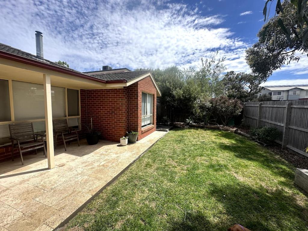 a backyard of a house with a grass yard at Beach Escape Torquay in Torquay