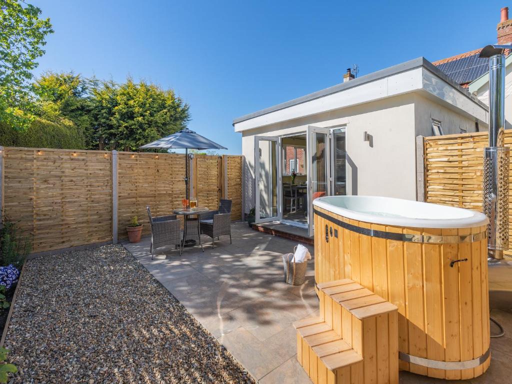 a backyard with a hot tub and a fence at Peacock Lodge in Thurlton