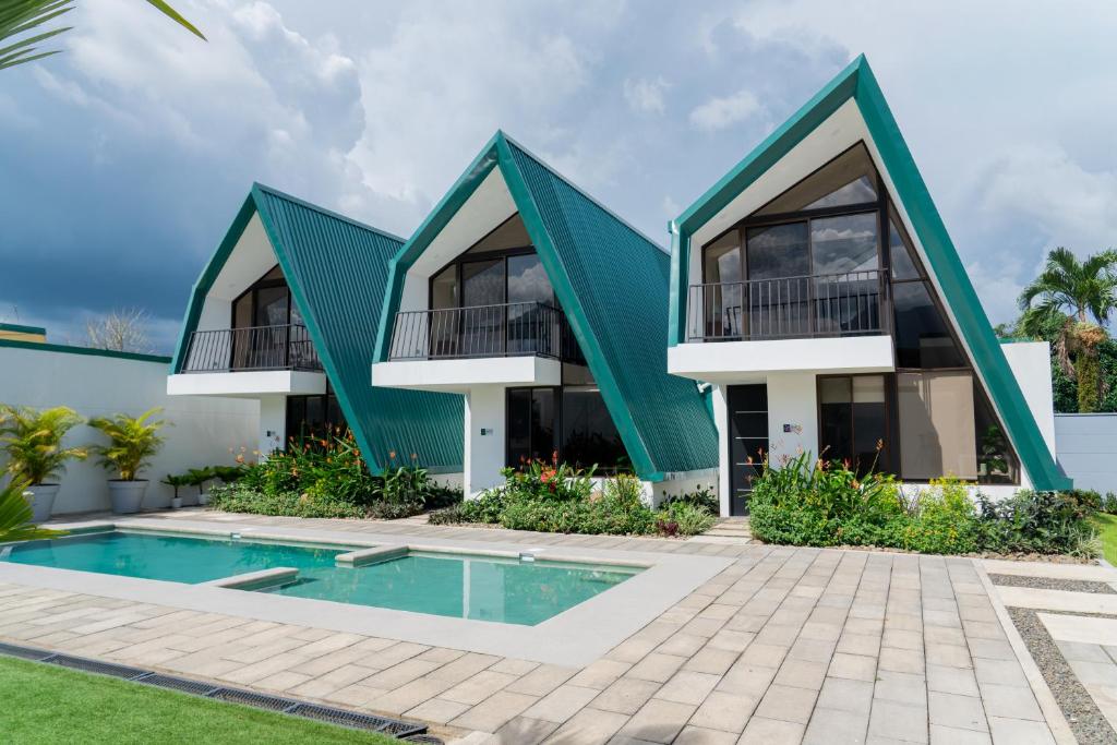 a house with a green roof and a swimming pool at Gival Paradise in Fortuna