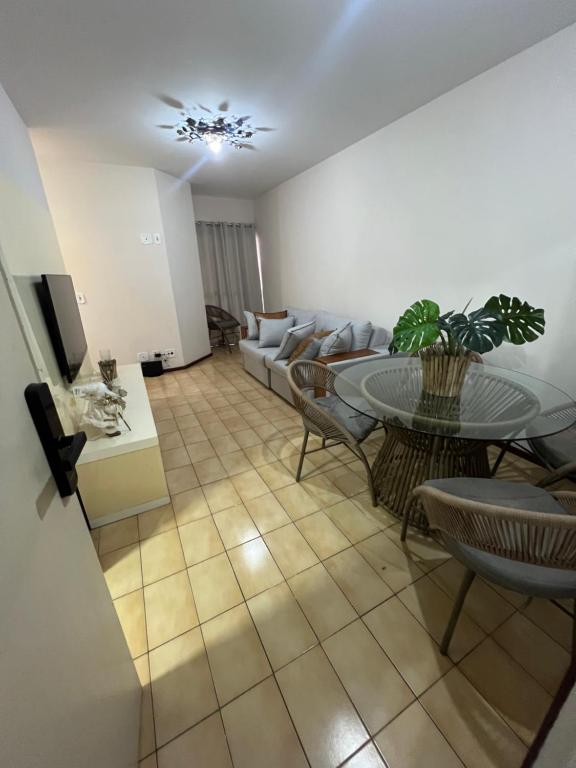 een woonkamer met een bank, een tafel en stoelen bij Apartamento 3 suítes perto da Praia do forte e Passagem in Cabo Frio