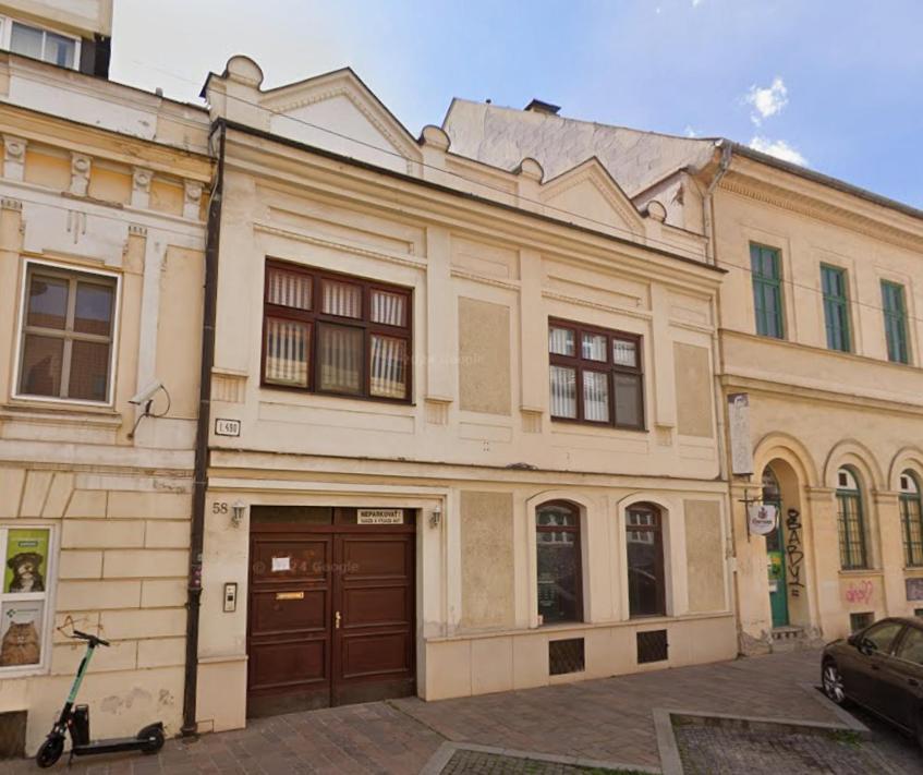 an old building with a car parked in front of it at Cassovia Hostel in Košice