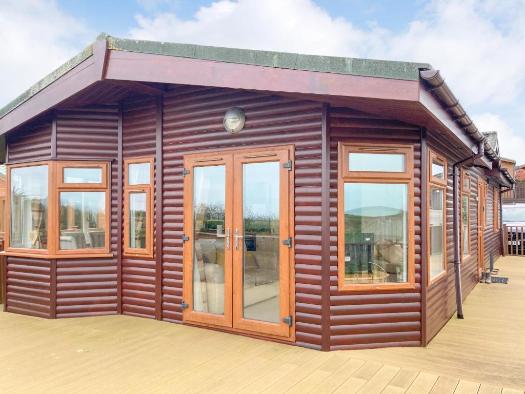 West DownにあるGrandma's Stick Houseの小さな木造家屋(デッキにガラスドア付)