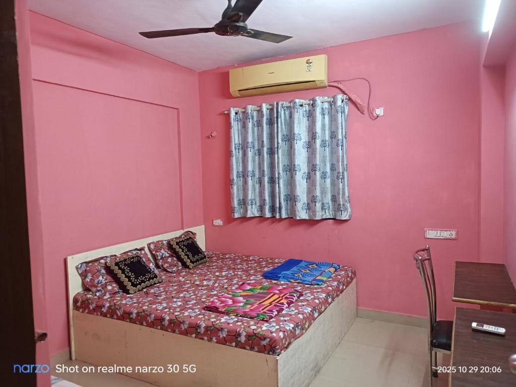 una camera con una parete rosa e un letto. di Private Room At Pushpanjali Residency Phase 2 Ghodbunder Road Ovale Thane West a Kolshet