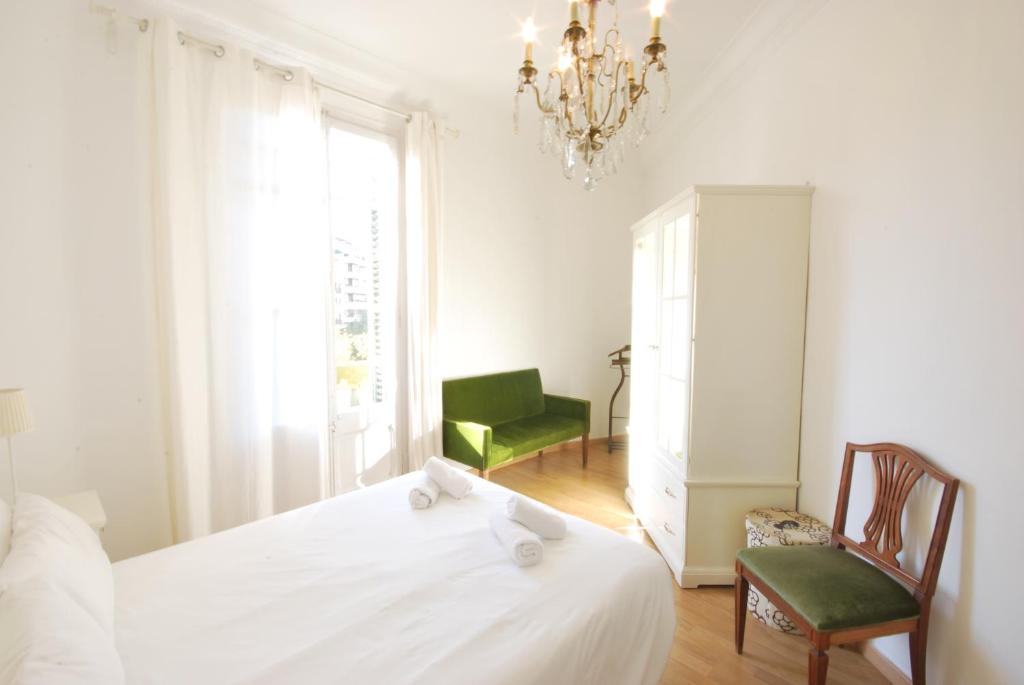 1 dormitorio con 1 cama, 1 silla y 1 lámpara de araña en Rocafort SDB, en Barcelona