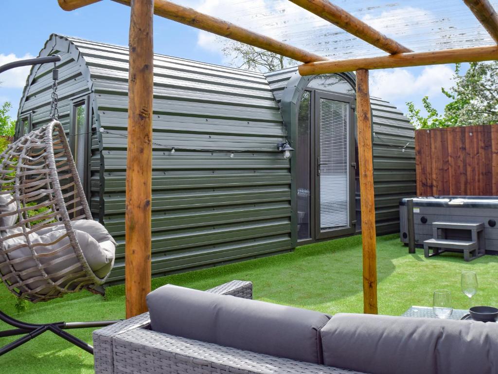 Un jardín moderno con una casa al fondo. en Laurel Pod - Uk47203, en Westhead