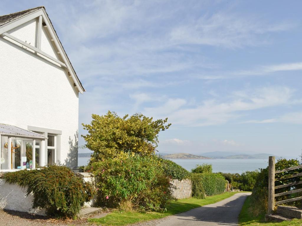 a white house with a view of the water at Balcary Mews Cottage in Auchencairn