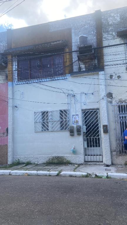 een wit gebouw met een hek aan de zijkant bij Casa da Mãe Maria in Belém