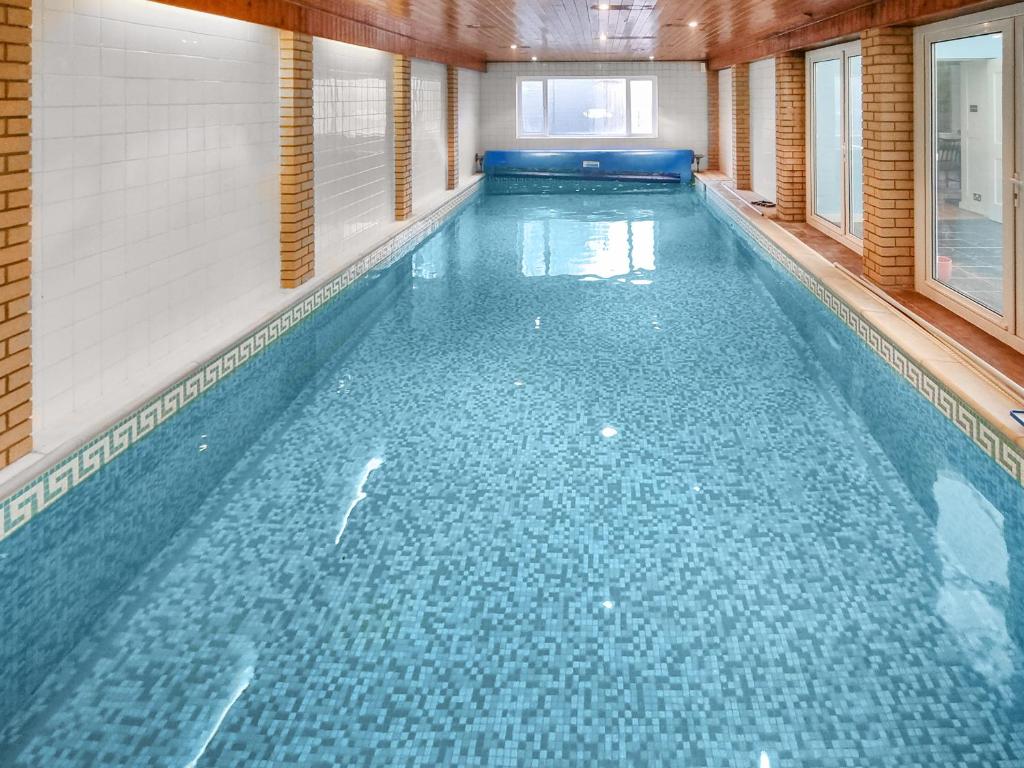 Una gran piscina con agua azul en un edificio. en Winthorp, en Ivychurch