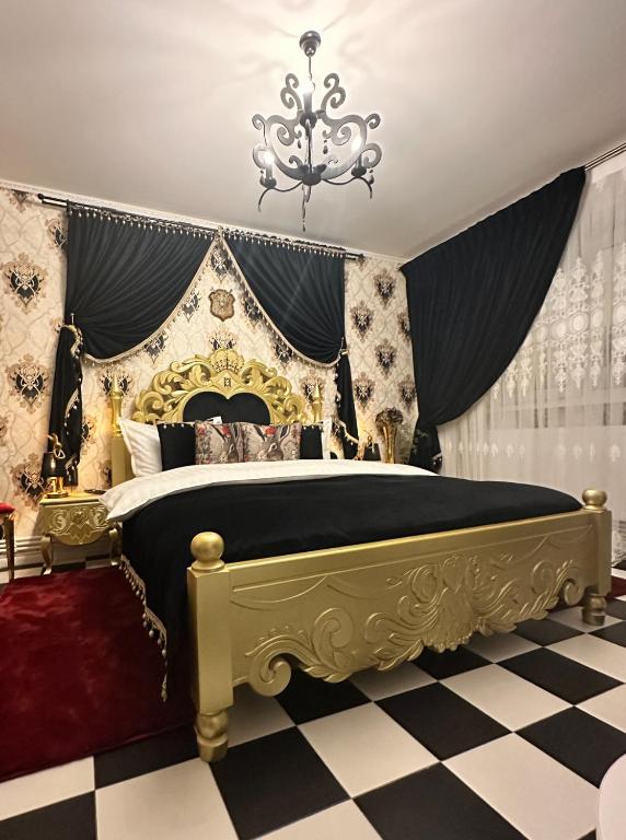 a bedroom with a gold and black bed with a chandelier at Wanderland by Eden Luxury in Brăila