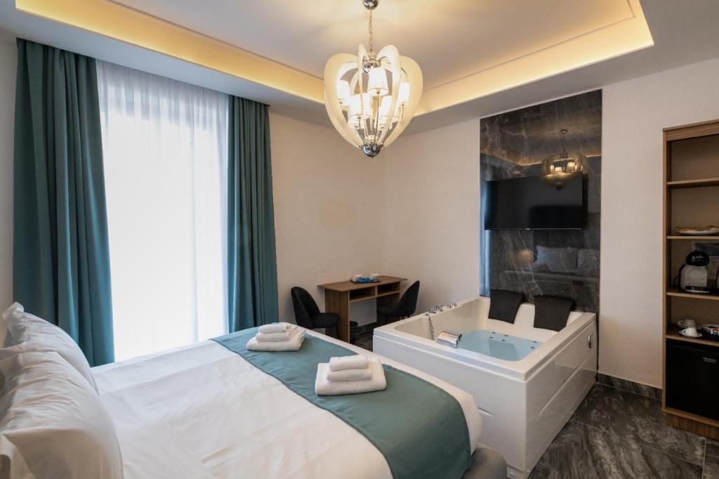 una camera da letto con un letto, una vasca e un lavandino di Mare Luxury a Napoli
