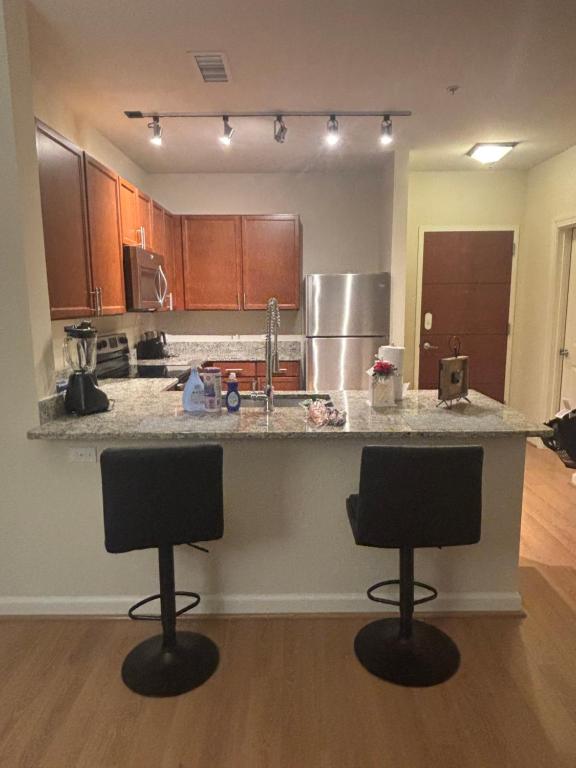 eine Küche mit zwei Barhockern vor einer Theke in der Unterkunft Modern& stylish vibe in Fairfax