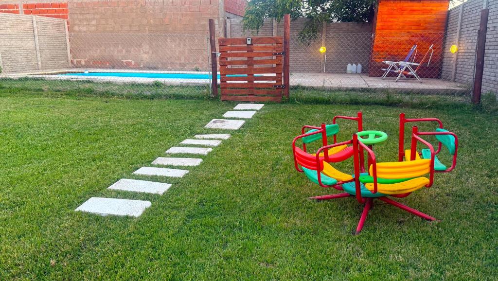 a colorful playground in the grass next to a pool at Departamento por dia in Pehuajo