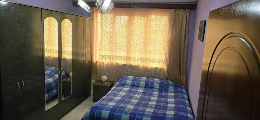 a bedroom with a blue bed and a mirror at Cozy Home in Tirana