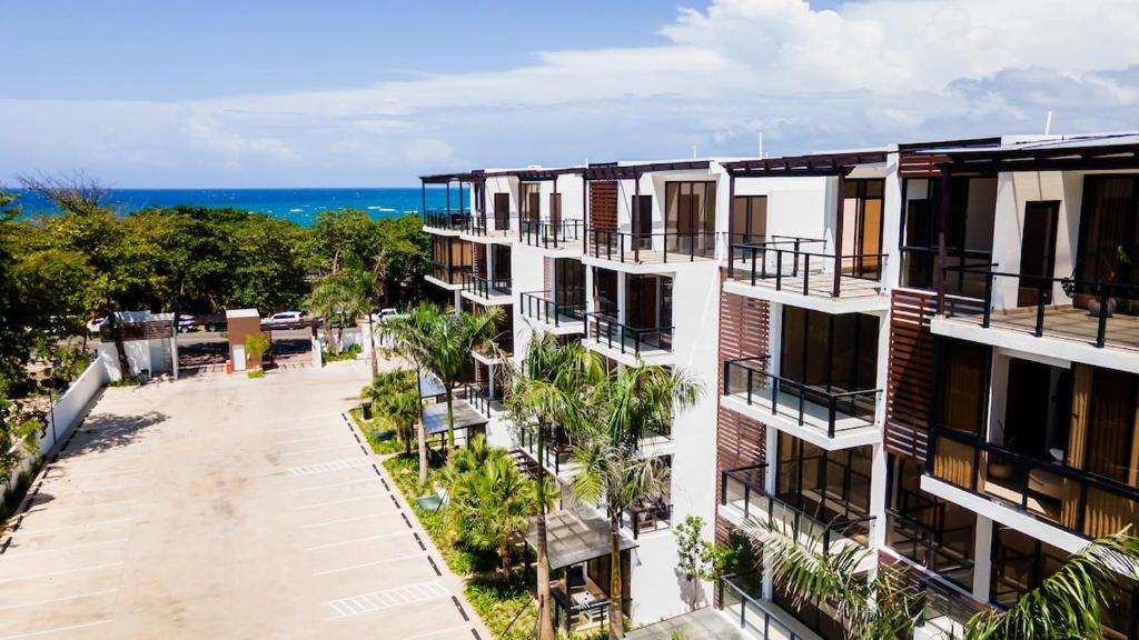 an apartment building with the ocean in the background at Tropical Getaway with pool & steps to the beach in Puerto Plata