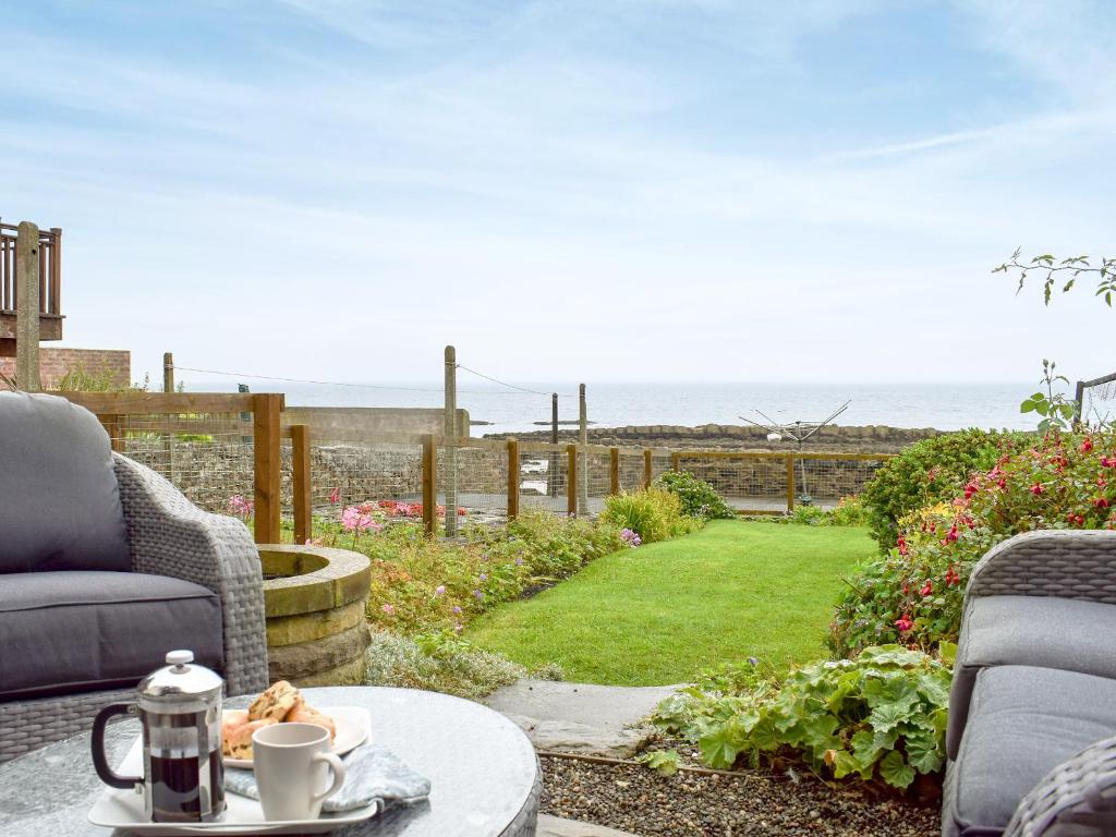 Un patio con mesa y vista al mar. en Making Waves, en Anstruther