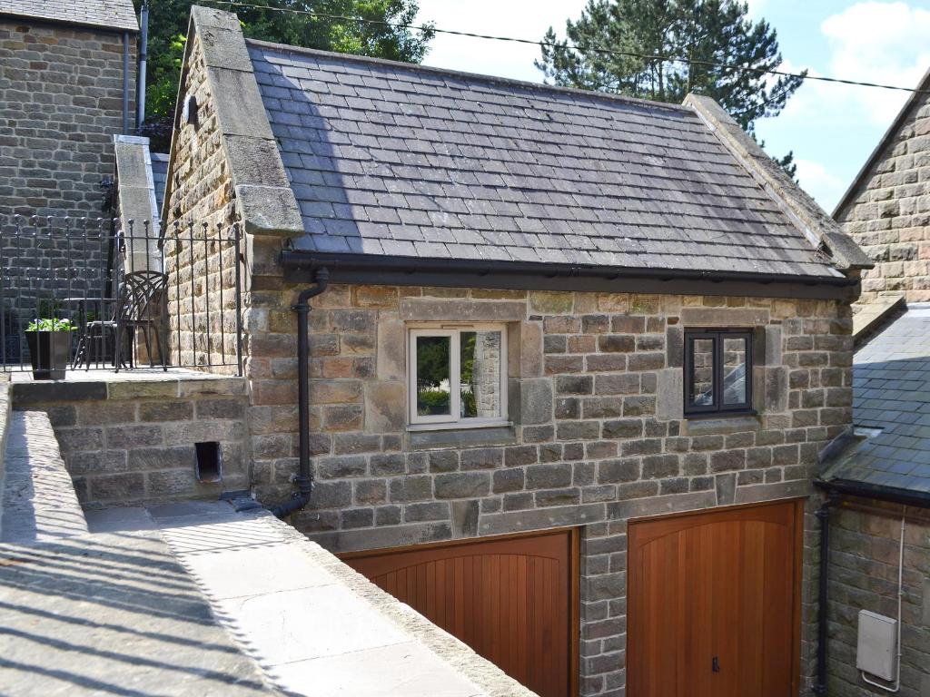 an old stone house with a garage at The Old Vicarage in Curbar