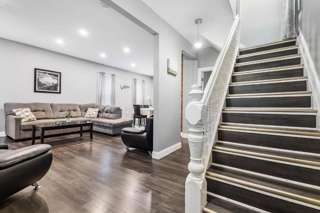a living room with a staircase and a couch at Modern 5BR Home Perfect for Families in Niagara Falls