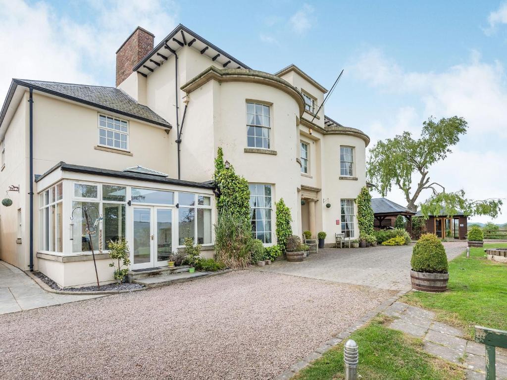 een groot wit huis met een oprit bij Edderton Hall Country House in Forden