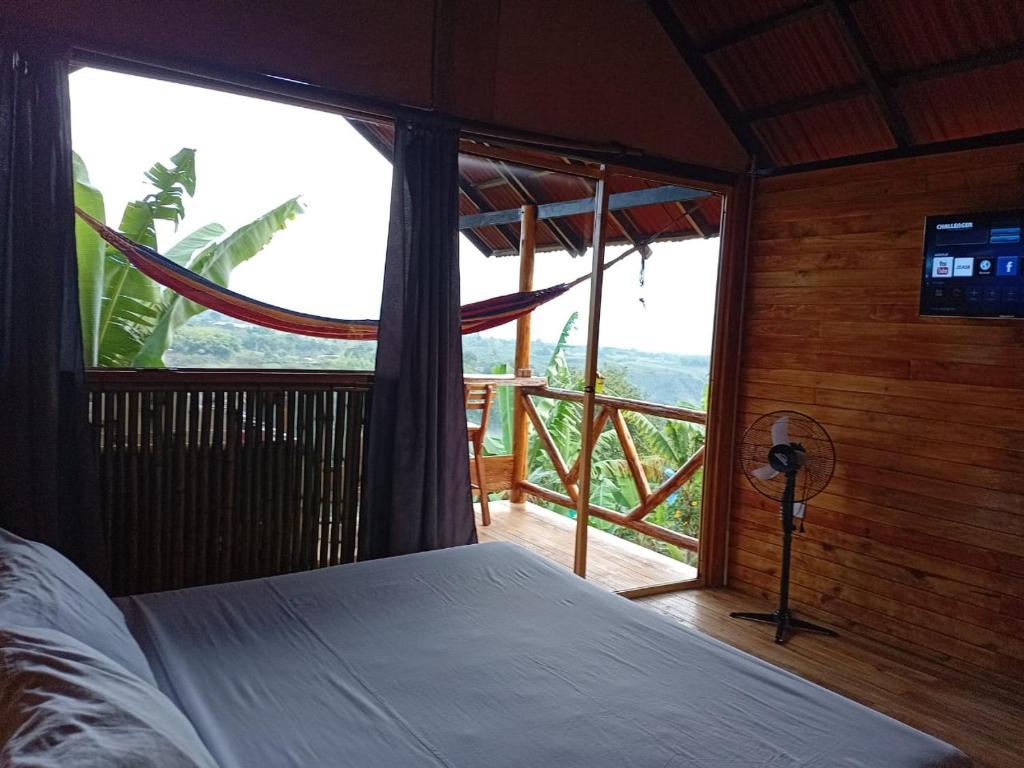 a bedroom with a bed and a large window at Cabañas la Miranda in Filandia