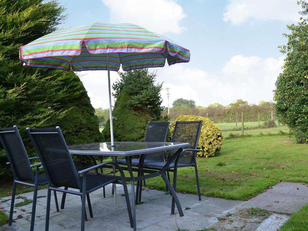 a table and chairs with an umbrella in a yard at Ty Clyd - Hw7657 in Walton East