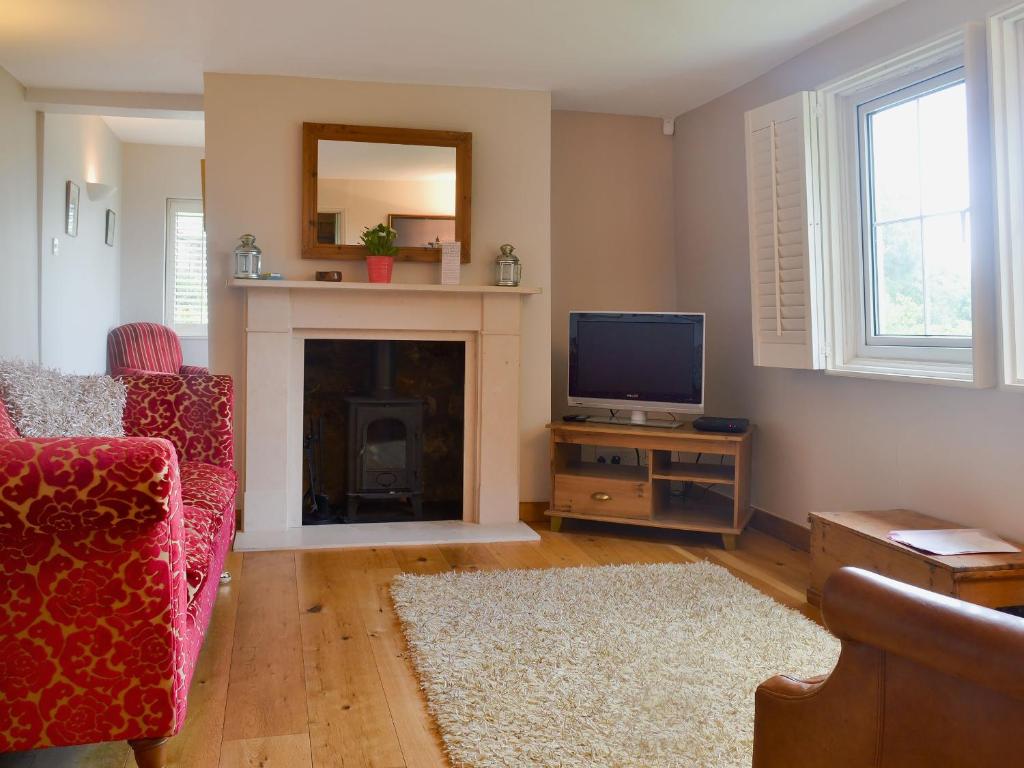 a living room with a fireplace and a tv at Eastwood Lodge in Bath