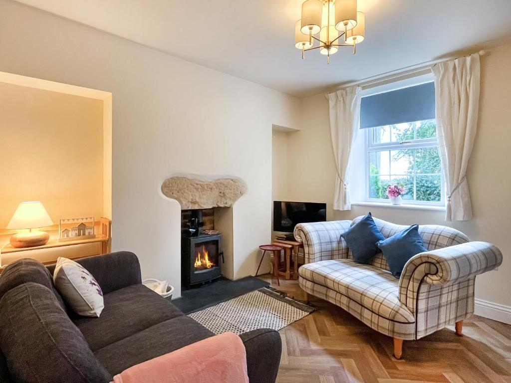 un soggiorno con divano e camino di Marsay Cottage a Loftus