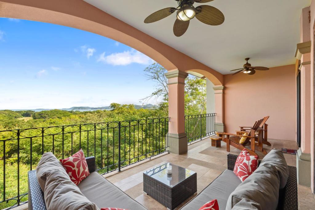 a living room with a couch and a balcony at Treetop Ocean View Penthouse - Jobo 15 in Playa Conchal