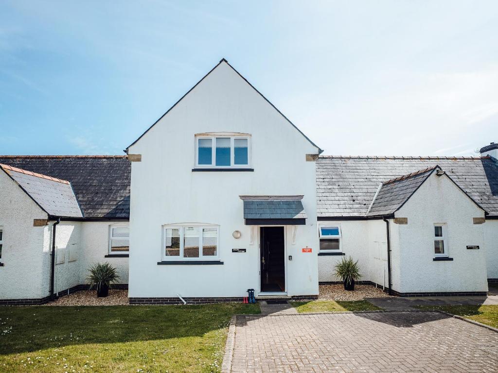 ein weißes Haus mit einem schwarzen Dach in der Unterkunft Puffin Cottage - Uk6731 in Lydstep