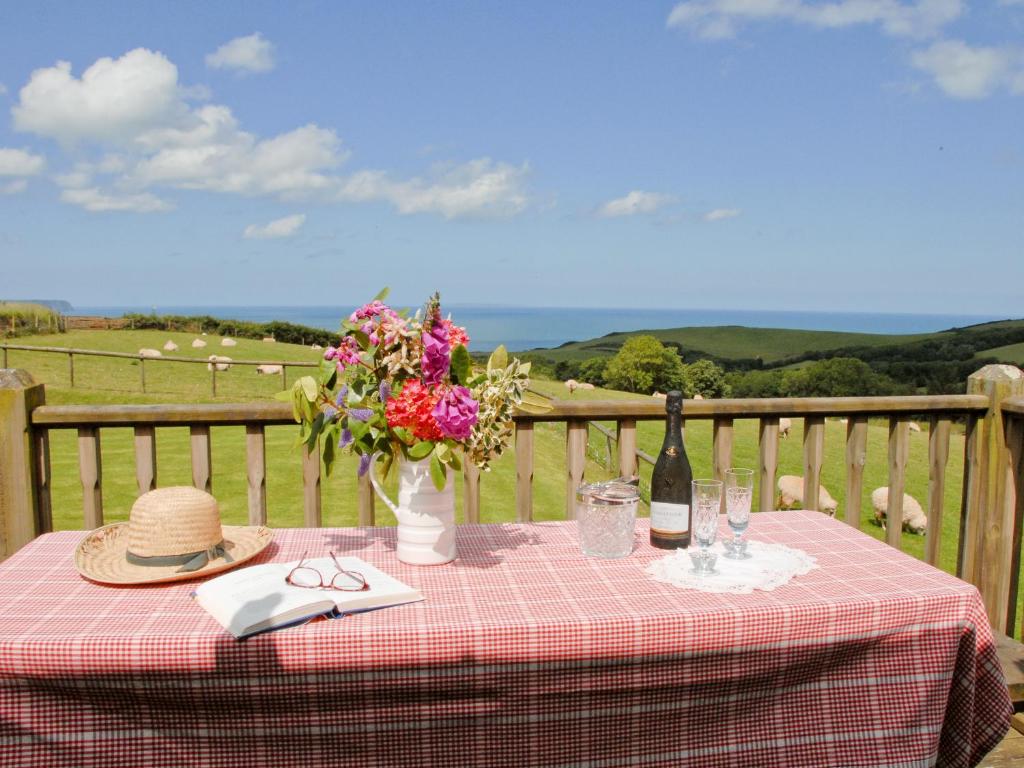 a picnic table with a bottle of wine and flowers at Chapman House in Parkham
