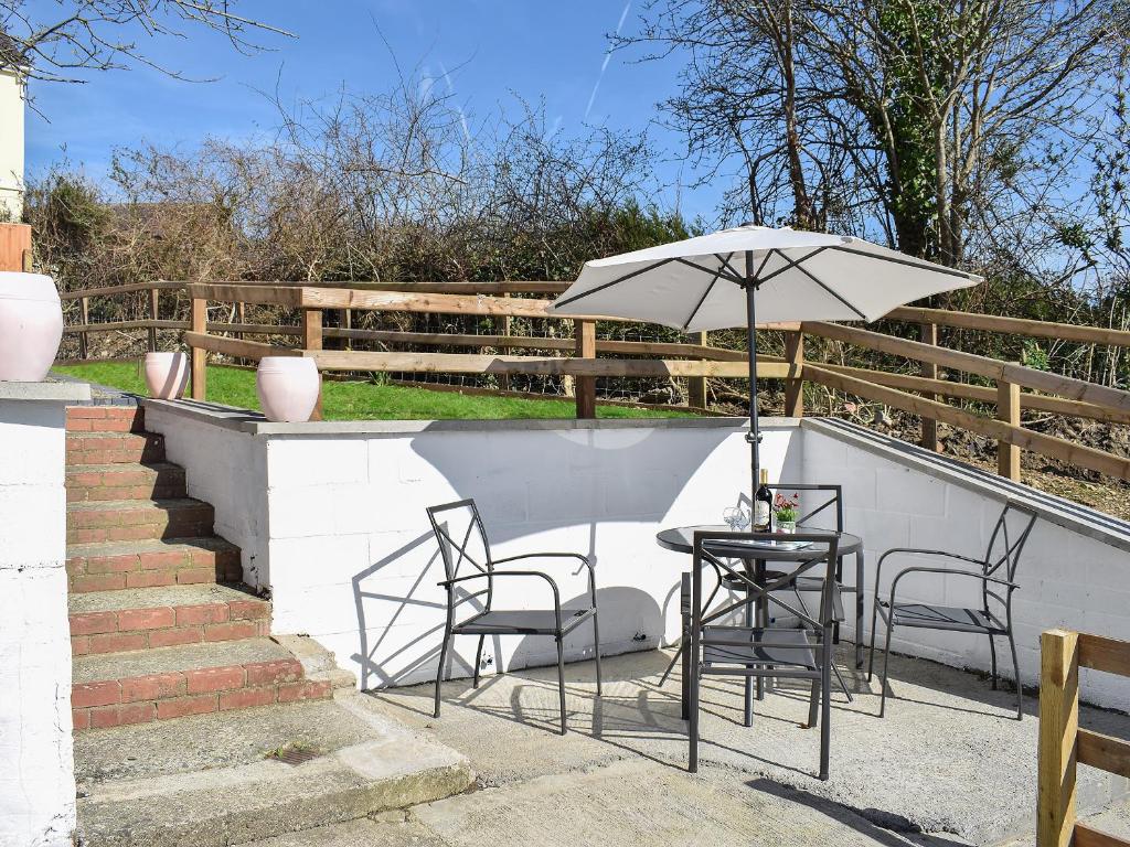 a table and chairs with an umbrella on a patio at Delfryn in Llanarth