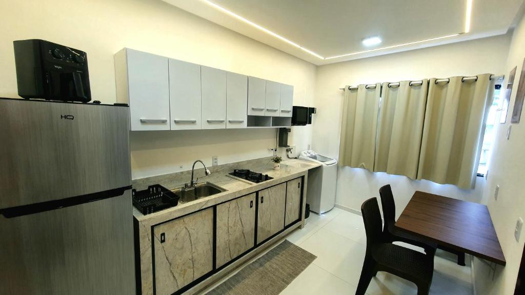a kitchen with a sink and a table in a room at Studio Centro Coité in Conceição do Coité