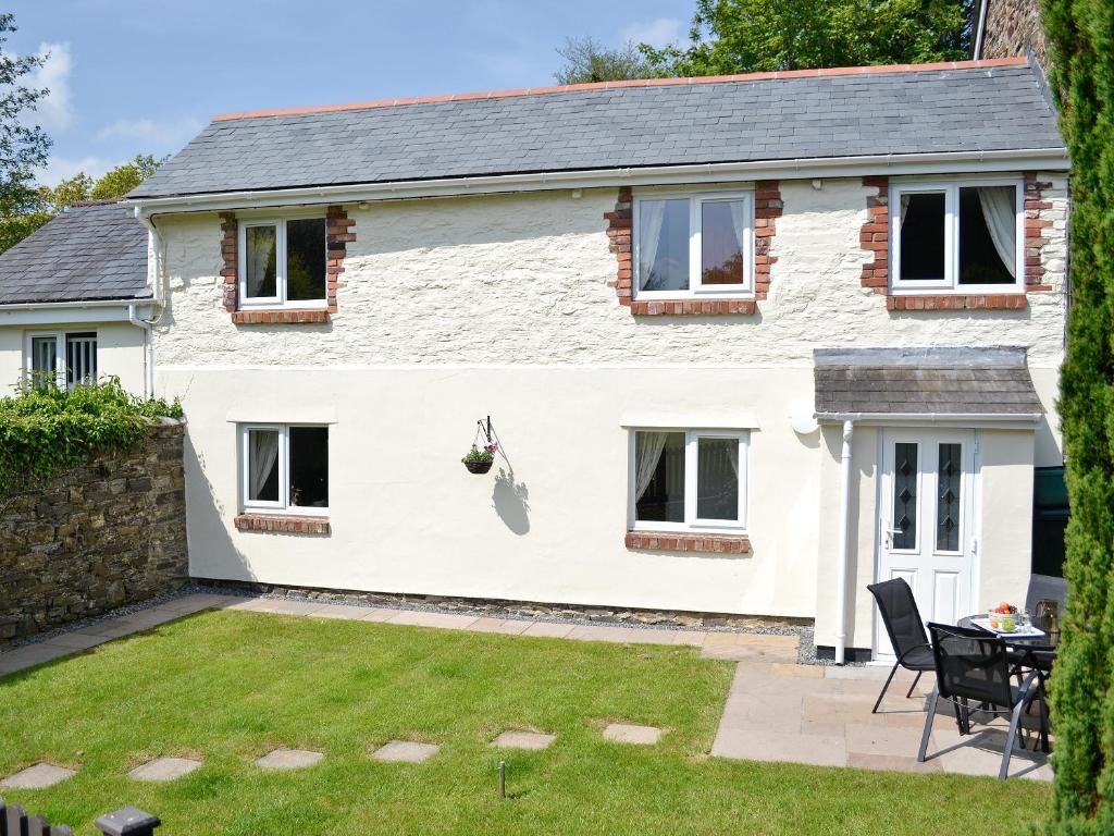 a detached house with a patio and lawn at The Lodge - 29794 in Swimbridge