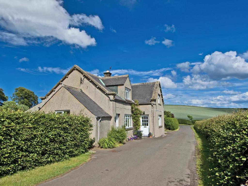 an old house on a road in the countryside at Foulden Hill Farm Cottage in Foulden