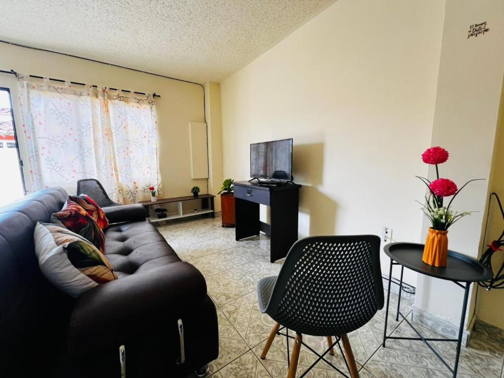 a living room with a couch and a tv at Casa Rincón in Curití