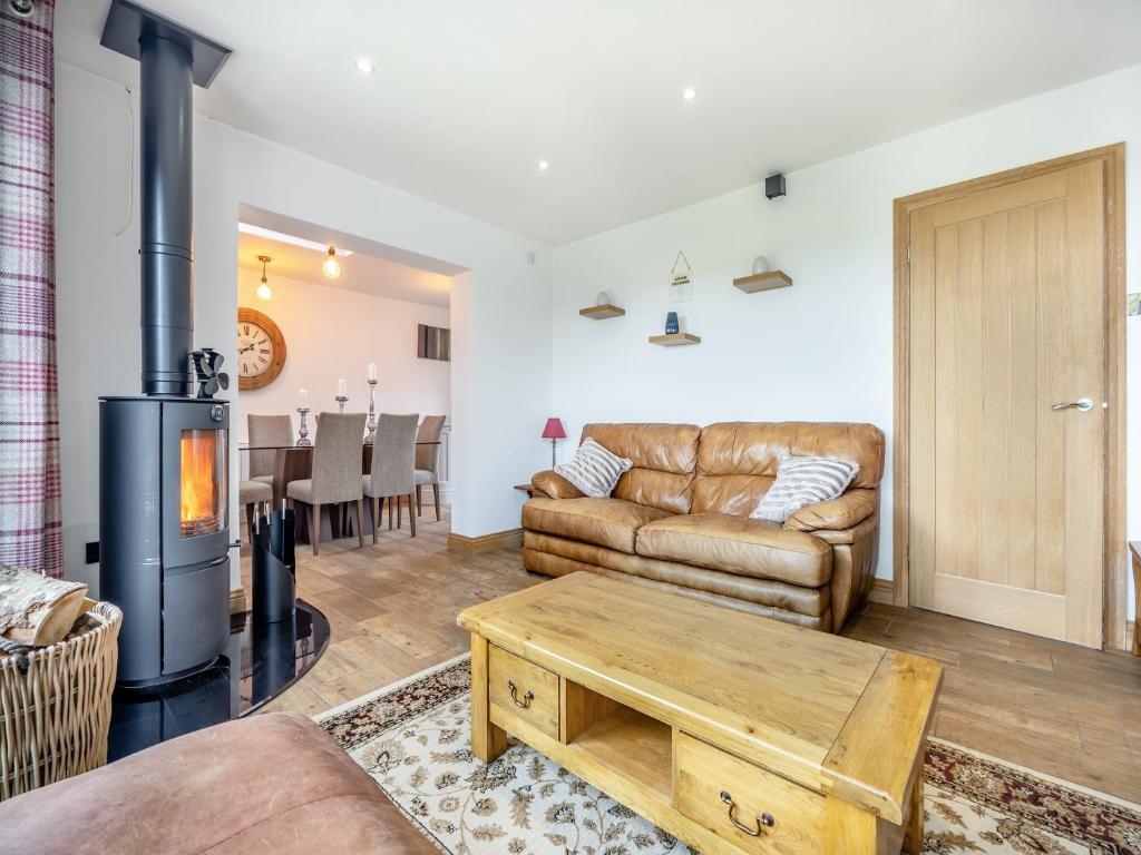 a living room with a couch and a wood stove at The Hideaway in Chapel Saint Leonards