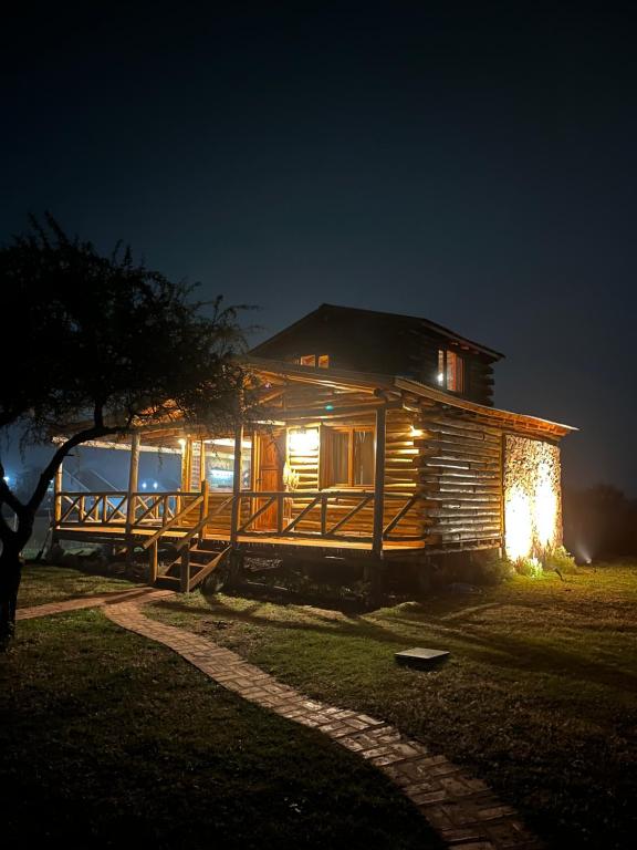 a log cabin at night with its lights on at Cabaña La Maura in La Estancia