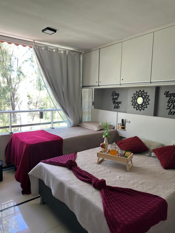 a bedroom with two beds and a window at Praia do Carneiros Flat Hotel, AP 303 Ap comandado por alexa in Tamandaré