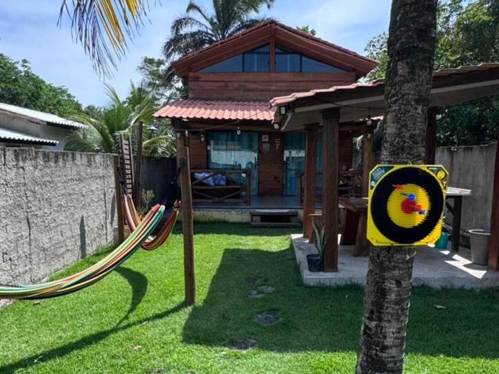 een speeltuin met een hangmat voor een huis bij Chalé de Madeira, a 60m do mar em condomínio in Vera Cruz de Itaparica