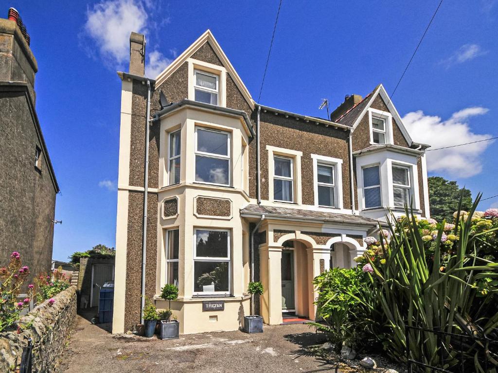 a large brick house with white windows and plants at Captain's House in Morfa Nefyn