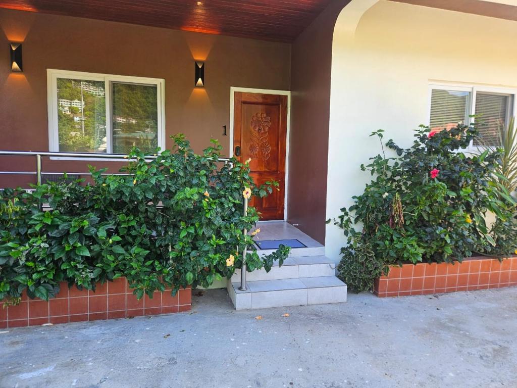 a house with two large plants on the front door at Agape Suites-Room 1- Ground Floor in Soufrière