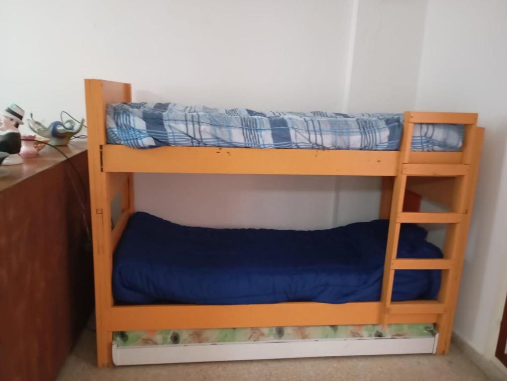 two bunk beds in a room with blue sheets at Departamento San Bernardo - 4 Ambientes - Cochera - Parrilla in San Bernardo