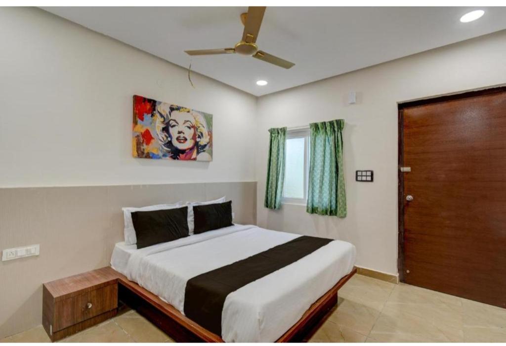 Un dormitorio con una cama y un ventilador de techo. en Hotel EVA, en Gundipet