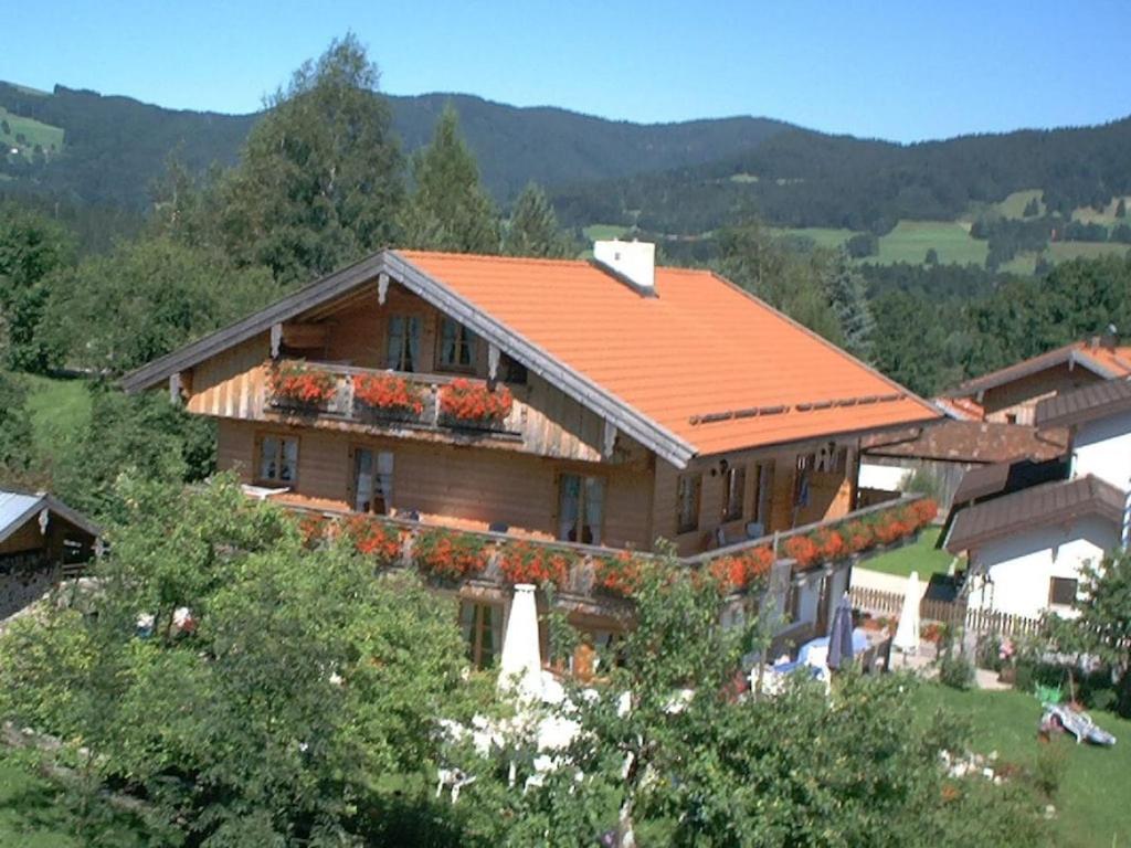 a house with an orange roof with flowers on it at Gentian in the Wendelstein holiday home in Fischbachau