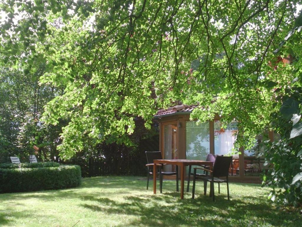 a table and chairs under a tree in a yard at Holiday apartment with 2 bedrooms in Sinsum