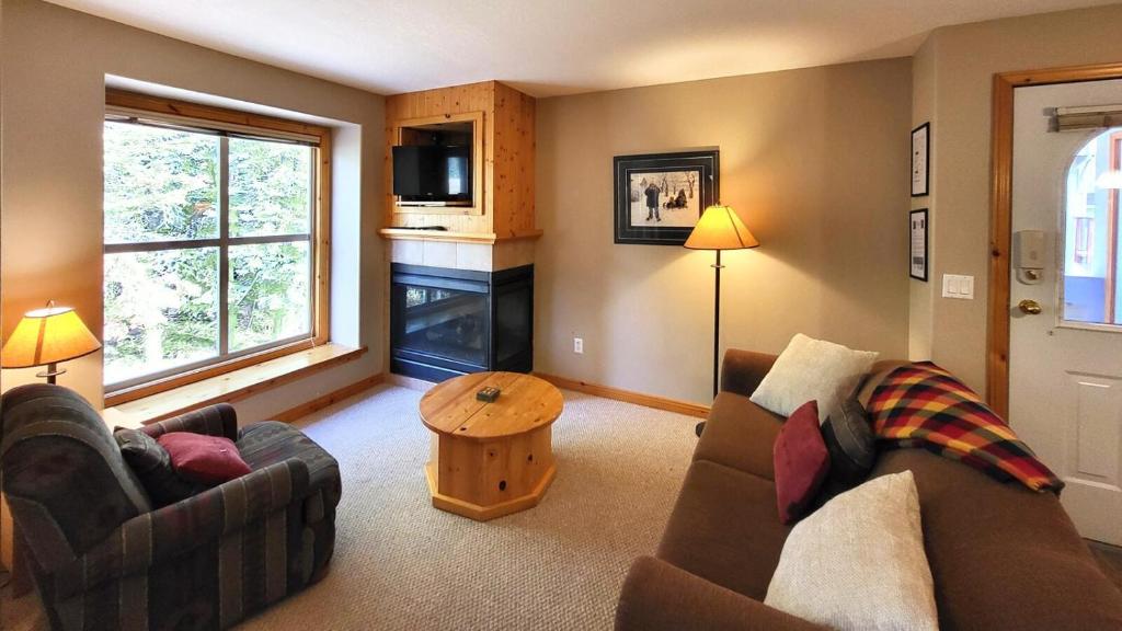 ein Wohnzimmer mit zwei Sofas und einem Tisch in der Unterkunft Crystal Forest #11 By Bear Country in Sun Peaks