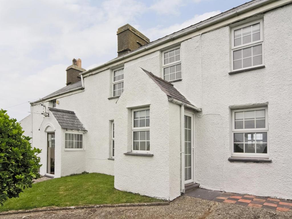 a white house with windows and a grass yard at Riffli - Hw7700 in Abersoch