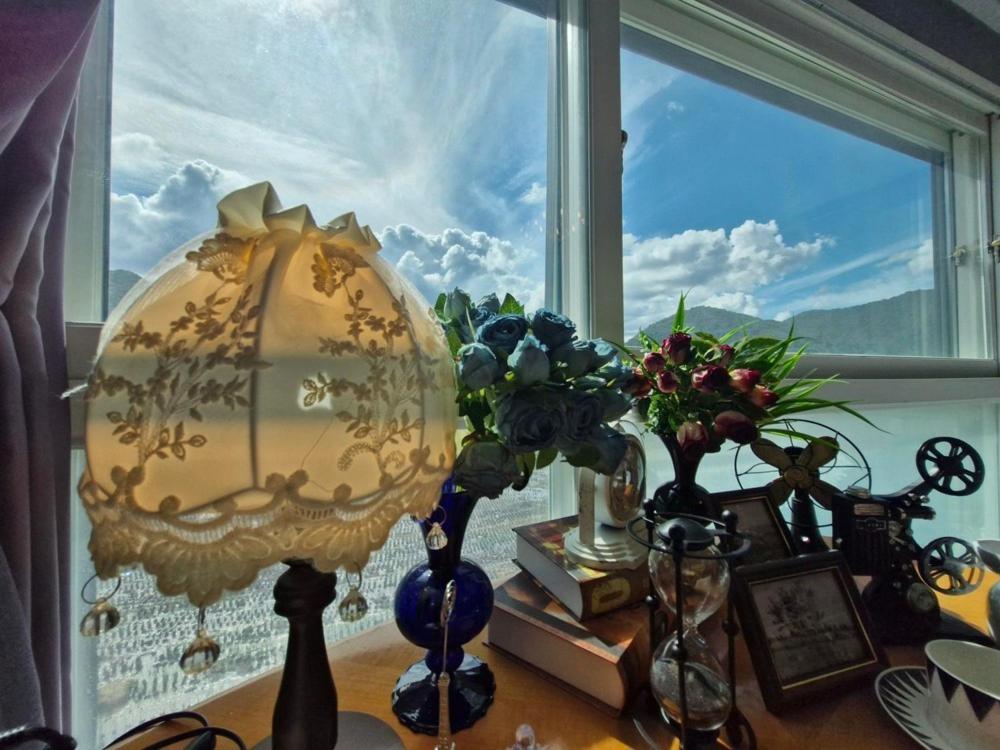 a table with a lamp and some vases and a window at Gangneung Jeongdongjin Gianni Pension in Gangneung