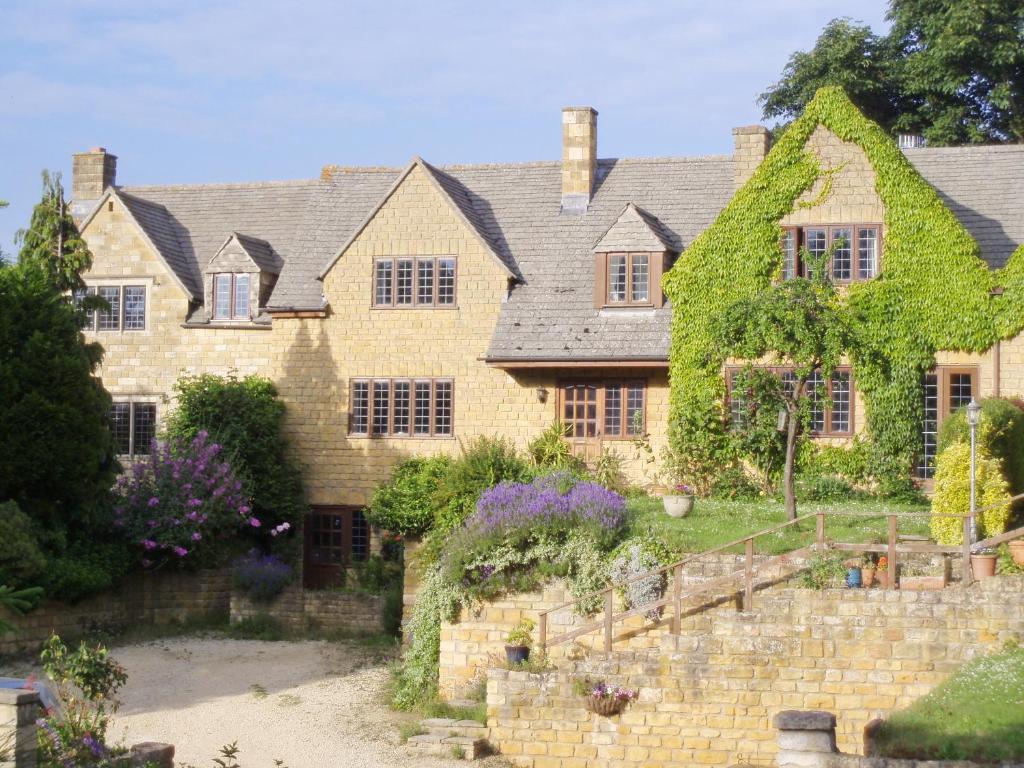 a large stone house with ivy on it at Orchard House in Chipping Campden